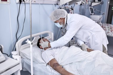 Genç, yaralı bir erkek hasta odasında yatıyor. Sağlık durumu kötü.