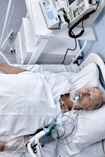 Maschio caucasico anziano affetto da coronavirus o covid-19. paziente costretto a letto. vista dall'alto — Foto Stock