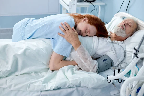 Hermosa hembra vino a visitar a papá o abuelo, que se encuentra en la moderna sala de hospital — Foto de Stock