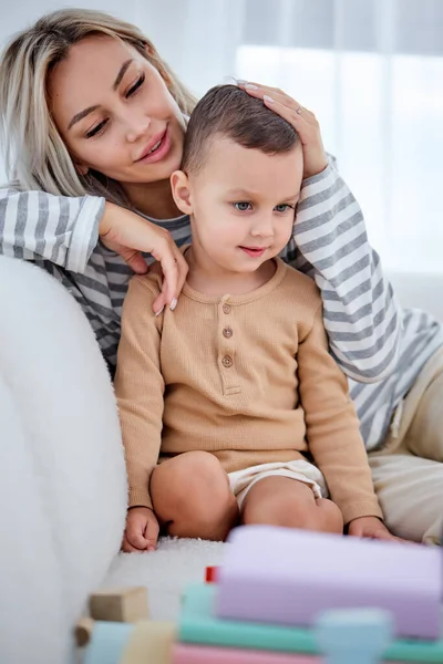 Femme insouciante parent se repose avec enfant d'âge préscolaire dans le salon sur le canapé à la maison. — Photo