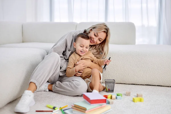 Sorrindo jovem mãe tem um bom tempo com o filho da idade pré-escolar, rindo — Fotografia de Stock