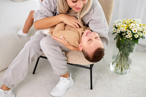 Cute little boy and cuddle pretty young mum show love and affection, laughing — Stock Photo, Image