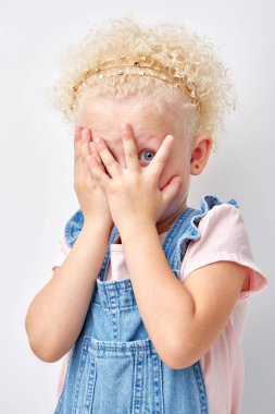duygusal küçük kız yüzünü kaplıyor beyaz arka planda izole edilmiş, korkmuş.
