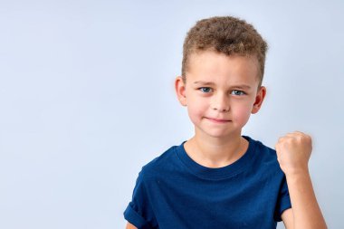 Yakışıklı çocuk kızgın görünüyor. Çocuk alınıyor, tehdit ediyor, yumruğunu gösteriyor. beyaz üzerine izole