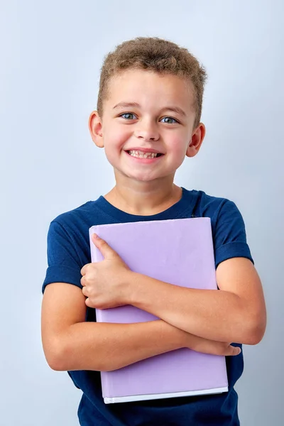 Porträtt av attraktiva unga glada skolpojke, leende, hålla kramar bok — Stockfoto