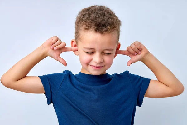 Niño pequeño cerrando los ojos y descontento cerrando las orejas con las manos, irritado — Foto de Stock