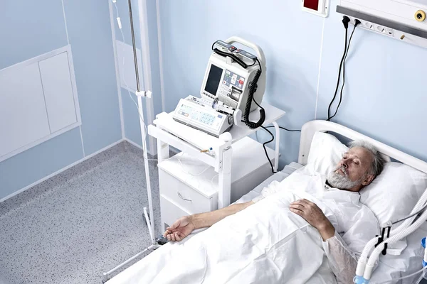 Malato paziente di sesso maschile anziano in ospedale letto. Concetto di assistenza sanitaria e trattamenti. — Foto Stock