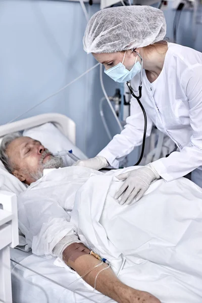 Senior Man Patienten får konsultation från sjuksköterska som använder stetoskop för hjärtslag examen — Stockfoto