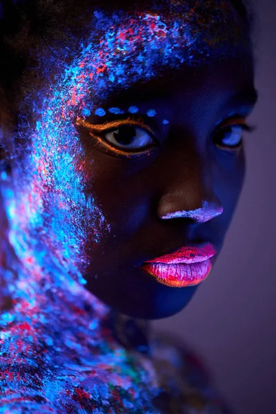 Foto sensual de jovem mulher negra deslumbrante com maquiagem flurescente no corpo — Fotografia de Stock