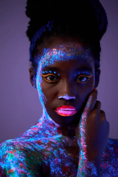 Mujer modelo extraterrestre en luz de neón. modelo negro con maquillaje fluorescente —  Fotos de Stock