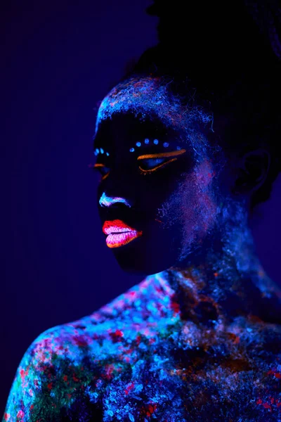 Retrato de um atraente jovem modelo feminino em luz negra brilhante bodyart — Fotografia de Stock