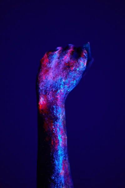 Gebalde vuist hand close-up op donkerblauwe achtergrond conceptuele studio — Stockfoto