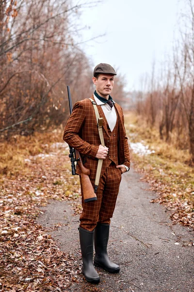 Genç erkek avcı avlanacak, kahverengi takım elbiseli ve şapkalı. — Stok fotoğraf