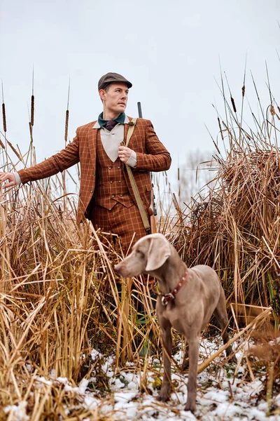 Temporada de caza de otoño. Cazador con perro y escopeta a la caza. Caza de otoño. — Foto de Stock