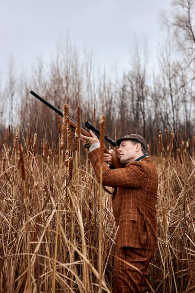 Lovecký samec. Střelec zaměřen na cíl. Období lovu. Muž s pistolí v poli. — Stock fotografie