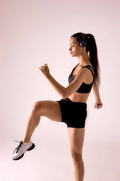 Oldal nézet portré fiatal fitness sportos nő fekete sportruházat pózol képzés — Stock Fotó