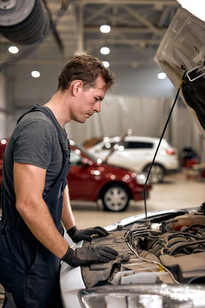 Mécanicien de voiture en faisant le service de réparation automobile et le travailleur d'entretien réparer le véhicule — Photo