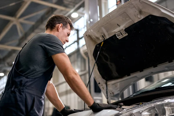 Professionele mannelijke auto service werknemer reparatie voertuig, stand-by geopende auto kap — Stockfoto