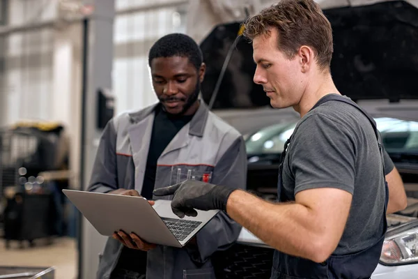 Team Of Diverse Auto Mechanic And Repairman Checking Diagnostics Results on Laptop. — Stock fotografie
