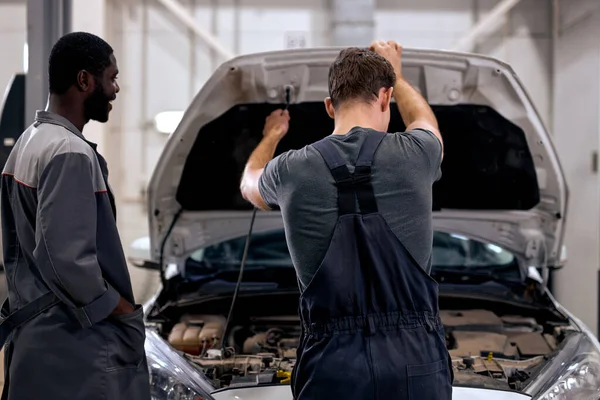 Los hombres negros y americanos pueden arreglar cualquier cosa. mecánica del coche en uniforme de control del motor — Foto de Stock