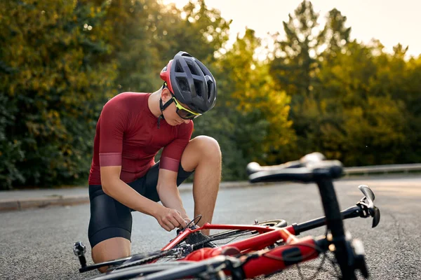 Masculino ter parado, estar ao ar livre, fixação de bicicleta por forças próprias, mudando detalhes — Fotografia de Stock