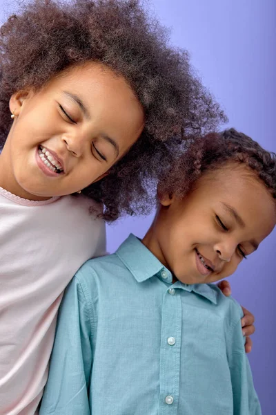快乐的兄妹在一起玩得很开心 摆出一副孤立在紫色工作室背景下的样子 穿着休闲装的快乐微笑的孩子的肖像 兄弟关系 家庭观念 — 图库照片