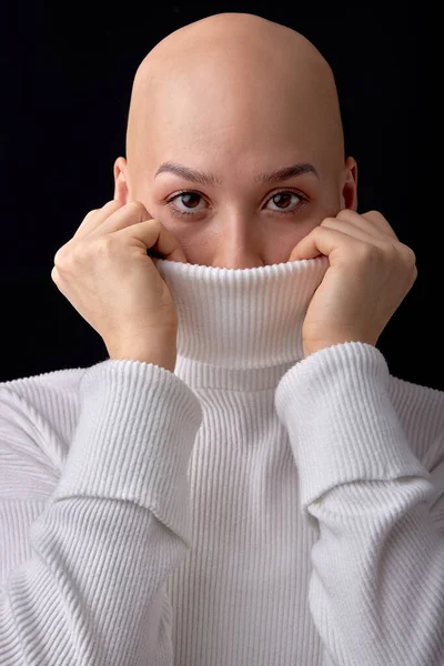 用白色温暖的衬衫盖住半个脸的高加索秃头女性的特写 自信地看着相机 隔离在黑色的工作室背景 复制空间 肿瘤学 白内障 — 图库照片