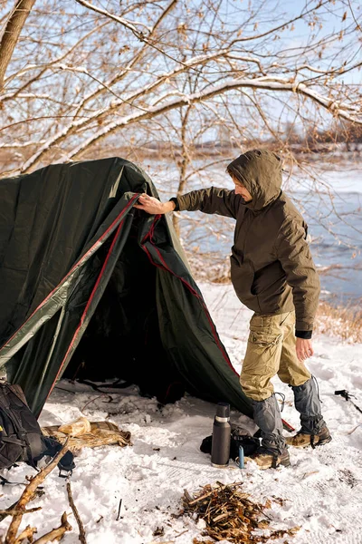 森の中にテントを張って森の掃除をしてキャンプの準備をしてる 暖かい服を着た若い男だけだ ブッシュクラフト ハイキング 放浪の欲望の概念 — ストック写真