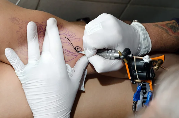 Tätowierer macht das Tattoo auf dem Arm — Stockfoto