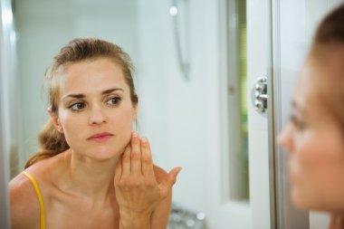 genç kadın banyo aynada yüzüne denetleme
