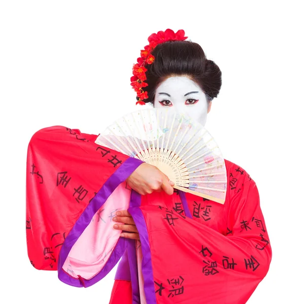 Портрет гейши, скрывающейся за вентилятором изолированной на белом — стоковое фото