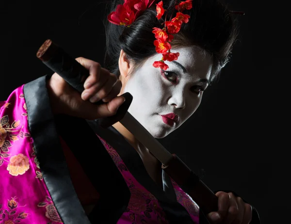 Portrait of geisha pulls out sword of sheath on black — Stock Photo, Image