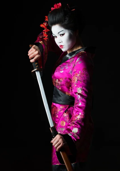 Portrait of geisha warrior pulls out sword of sheath on black — Stock Photo, Image