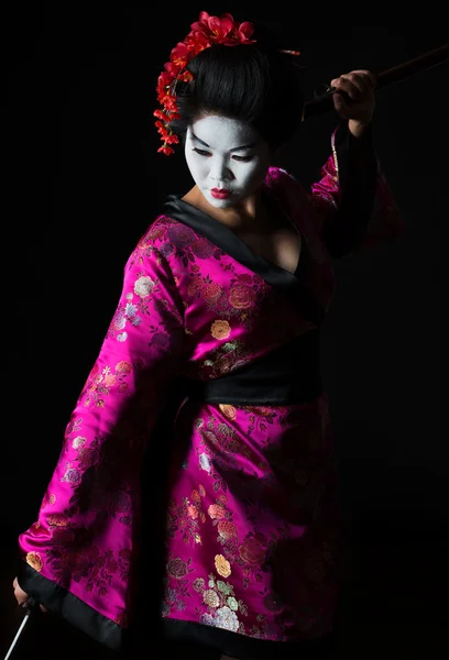 Портрет гейши, танцующей с мечом, изолированным на черном — стоковое фото