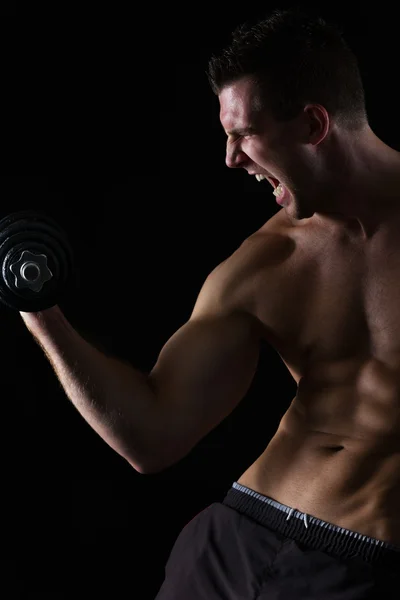 Angry atleta muscular bíceps treino em preto — Fotografia de Stock