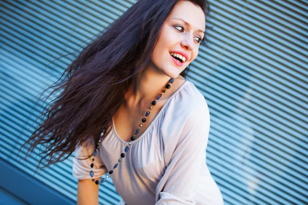 Sonriente chica mirando de lado sobre fondo azul — Foto de Stock