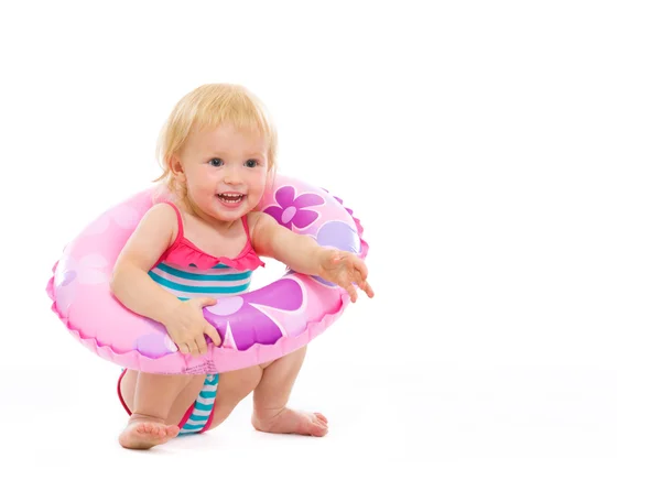 Bambina in costume da bagno seduta con anello gonfiabile — Foto Stock