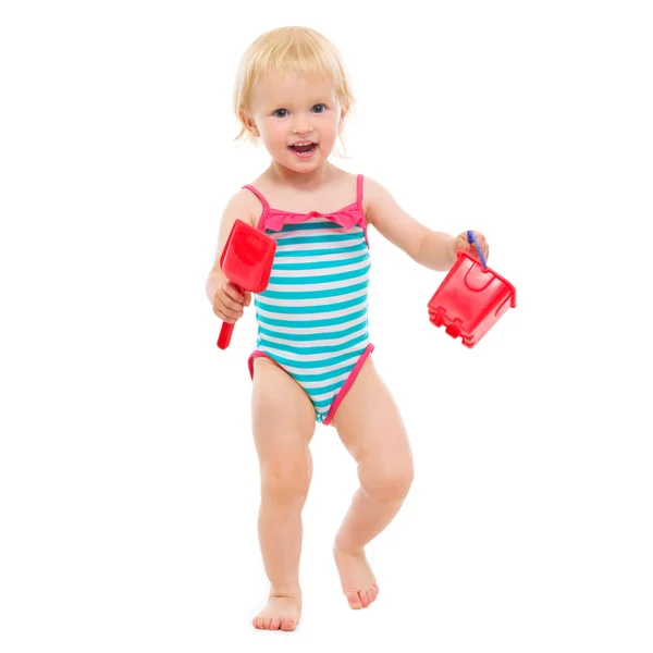 Niña en traje de baño sosteniendo cubo y pala — Foto de Stock