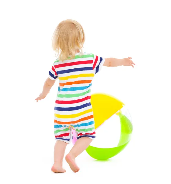 Baby in swimsuit playing with ball. Rear view — Stock Photo, Image