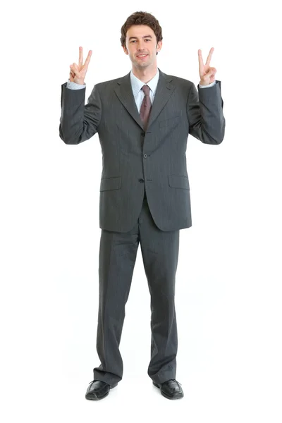 Full length portrait of businessman showing peace gesture — Stock Photo, Image