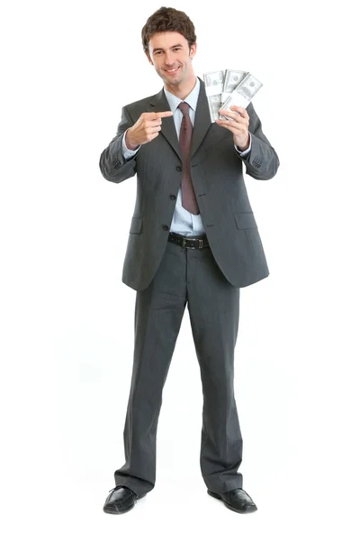 Un hombre de negocios sonriente apuntando a paquetes de dólares — Foto de Stock