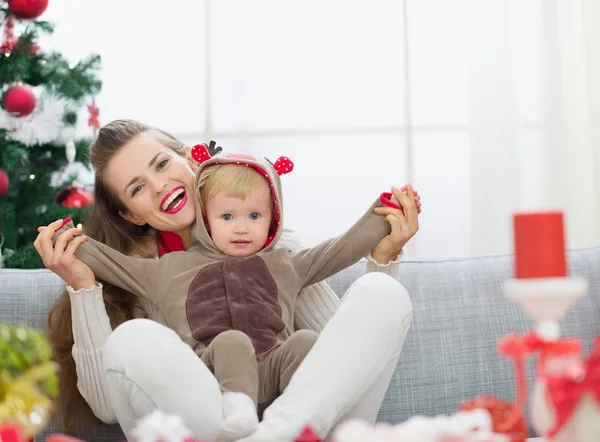 Lachende jonge moeder en baby plezier tijd op Kerstmis — Stockfoto