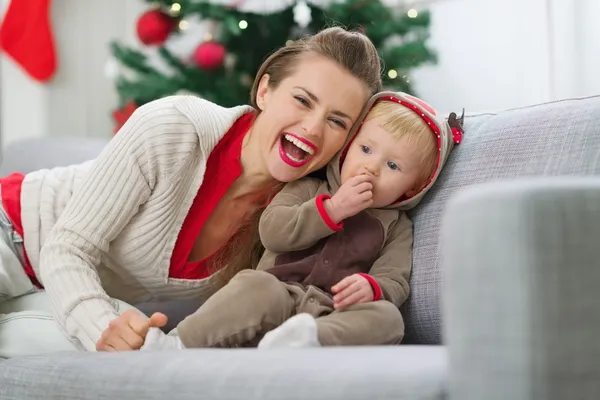 Gülümseyen genç anne ve bebek eğleniyor Noel zamanı — Stok fotoğraf