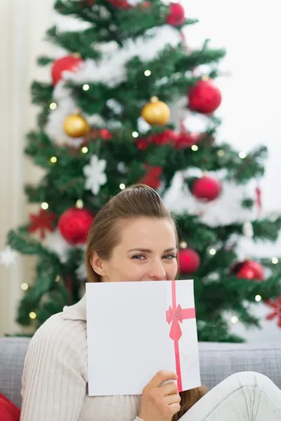 Žena schovává za vánoční pohlednice — Stock fotografie