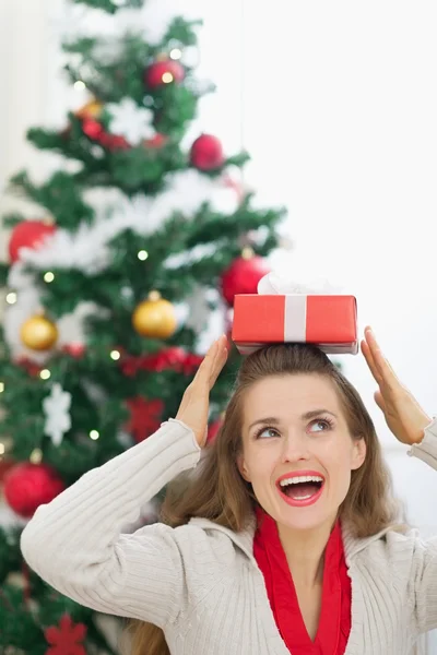 Glückliche junge Frau hält Weihnachtsgeschenkbox auf dem Kopf — Stockfoto