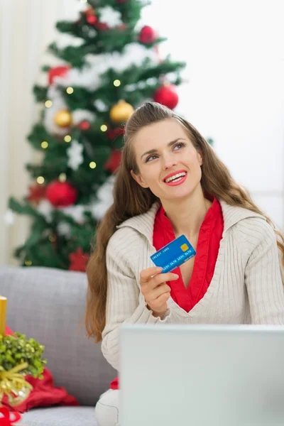 Woman with credit card thinking about Christmas presents — Stock Photo, Image