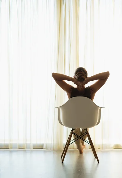 Mujer sentada frente a la ventana. Vista trasera — Foto de Stock