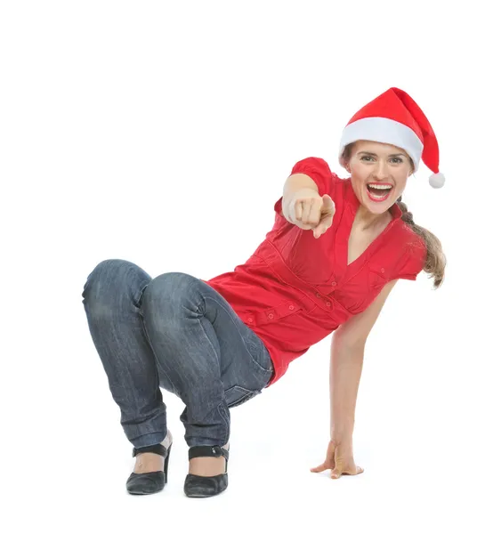 Glückliche Frau mit Weihnachtsmütze hockt auf dem Boden und zeigt auf c — Stockfoto