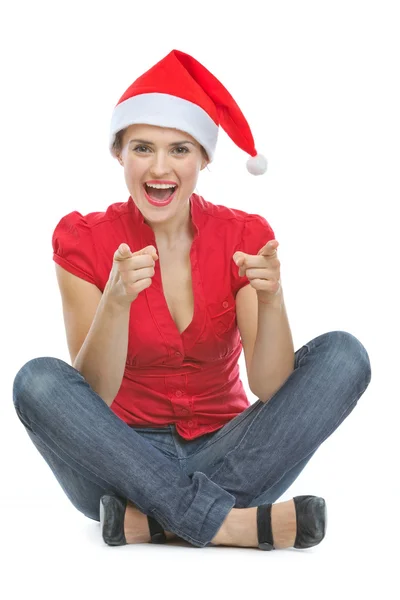 Mujer feliz en sombrero de Navidad sentado en el suelo y señalando en ca — Foto de Stock