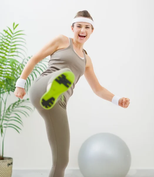 Happy fitness woman kicking in camera — Stock Photo, Image